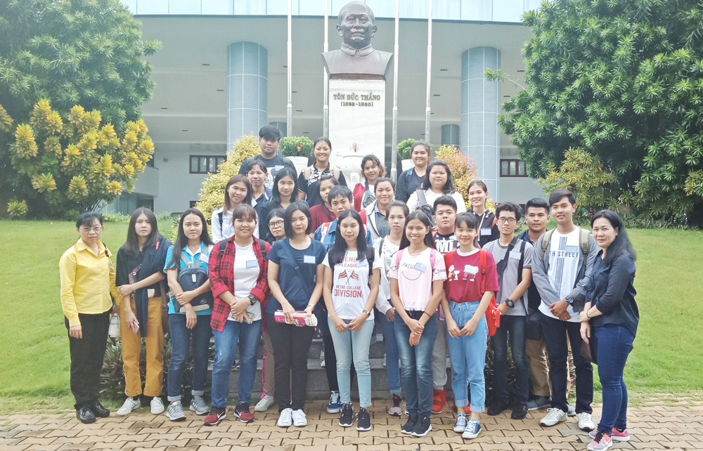 The Thai student delegation touring the university campus and taking photos at the statue of Uncle Ton