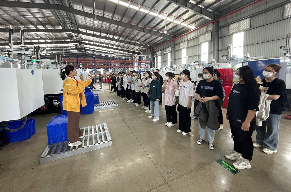 Company staff guide the students through the production process at the factory.