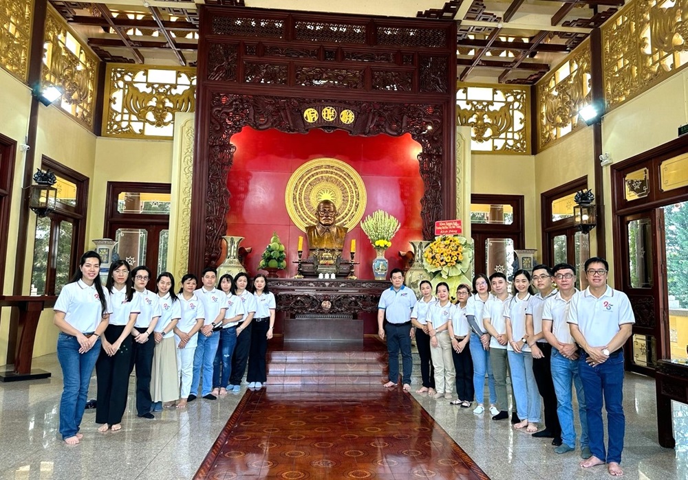 Tập thể viên chức và người lao động Khoa Ngoại ngữ chụp hình lưu niệm bên cạnh bức tượng đồng Chủ tịch Tôn Đức Thắng